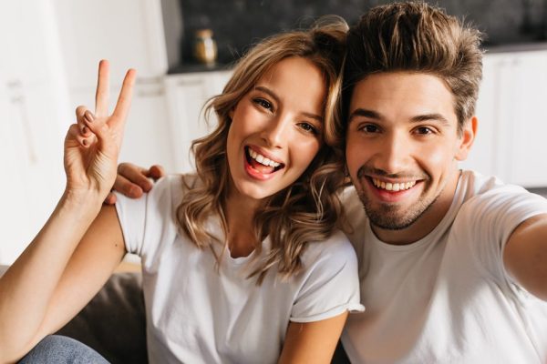 Joyful young man making selfie with his beautiful girlfriend at