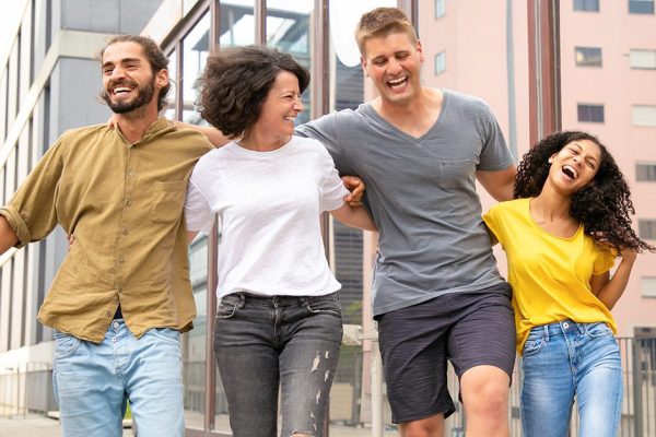 Happy carefree friends walking outside and having fun