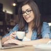 Beautiful hipster woman using laptop at cafe