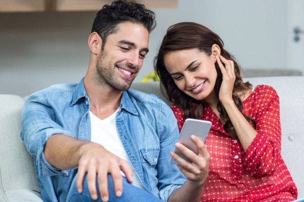 Smiling couple using phone