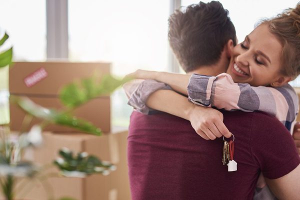 Happy couple with keys of new apartment