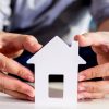 businessmen hold house model in hand