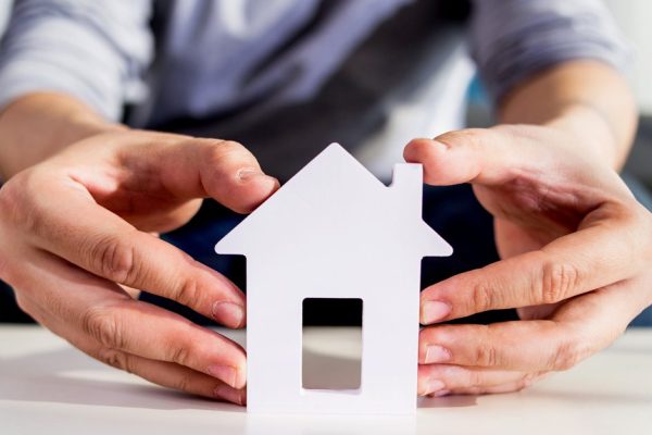 businessmen hold house model in hand