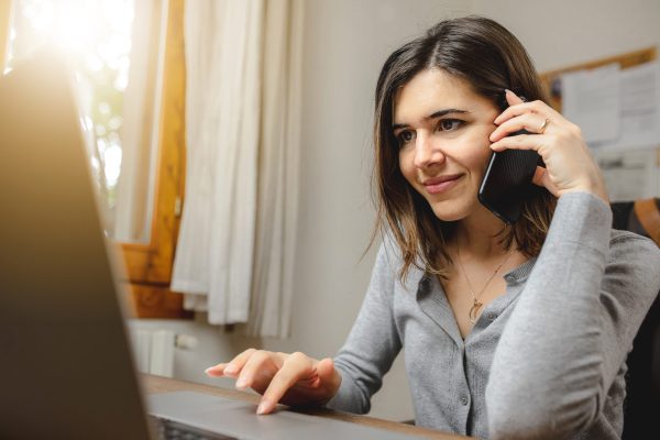 Woman,Talking,On,The,Phone,While,Working,On,Computer,In