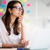 successful businesswoman working on laptop computer and thinks on new ideas in her office dressed up in white clothes