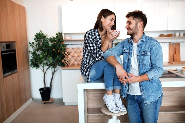 young happy man and woman in kitchen, breakfast, couple together in morning, smiling, having tea